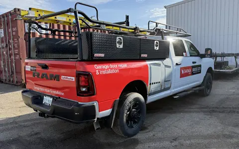 A pickup truck equipped with a ladder on the roof, ready for job use.